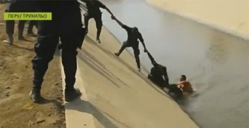 პოლიციელებმა ხელებით ჯაჭვი გააკეთეს, რათა არხში ჩავარდნილი ძაღლი გადაერჩინათ (+ვიდეო)